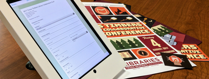 The registration site displayed on an ipad in front of the event poster.